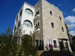 a large brick building with a fence in front of it at Siena Hotel in Jounieh