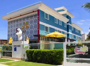 a blue building with an umbrella in front of it at Pousada SUN Victory in Cabo Frio