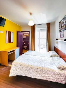 a bedroom with a large bed and a desk at Hotel Morfeo - Young People Hotels in Rimini