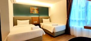 a hotel room with two beds and a window at MILAN HOTEL in Johor Bahru