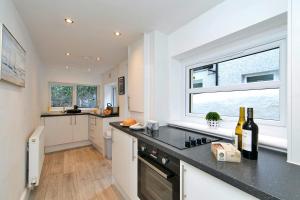 a kitchen with a window and a counter with wine bottles at Finest Retreats - Brook View in Colwyn Bay