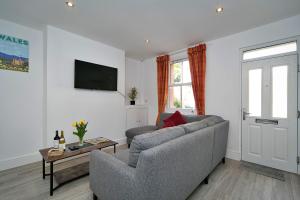 a living room with a couch and a tv at Finest Retreats - Brook View in Colwyn Bay