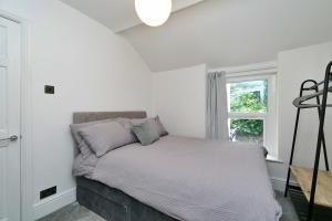 a bed in a white room with a window at Finest Retreats - Brook View in Colwyn Bay