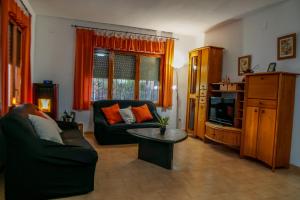 a living room with a couch and a tv at Xalet en Riumar,Delta del Ebro in Riumar