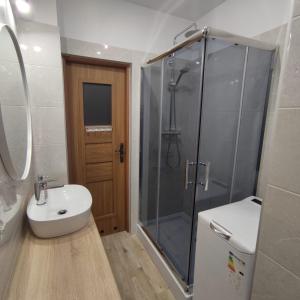 een badkamer met een douche, een wastafel en een toilet bij Apartament Brzeźno Plaża in Gdańsk