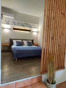 a bedroom with a bed with blue and white pillows at Coritos apartments 2 Corfu in Kontokali