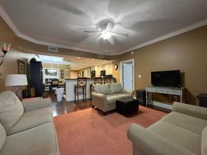 a living room with two couches and a tv at Treasure Island 2202 in Panama City Beach