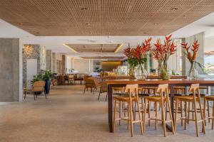 a restaurant with a large wooden table and chairs at Praiano Hotel in Fortaleza