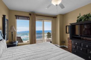 - une chambre avec un lit, une télévision et un balcon dans l'établissement Treasure Island 0202, à Panama City Beach