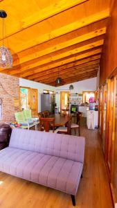uma sala de estar com um sofá roxo e uma mesa em Cabaña La Casona de Ripaluna em Paiguano