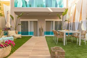 d'une terrasse avec une table et des chaises sur gazon. dans l'établissement G&M Luxury Residence with pool, à La Canée