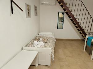 una piccola camera con un letto con due orsacchiotti sopra di KROKOS Ortigia a Siracusa