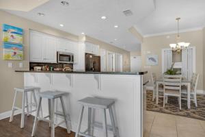 a kitchen with a bar and stools in a room at Treasure Island 0403 in Panama City Beach