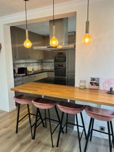 een keuken met een houten tafel en roze krukken bij Portofino - luxe appartement met lateraal zeezicht in Oostende +23 foto's