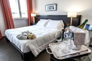 een hotelkamer met een bed en een dienblad met wijnglazen bij Hotel Mosaico & Residence in Ravenna