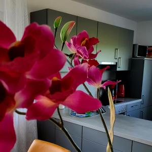 un ramo de flores rosas en una cocina en Ferienhaus Siebrands, en Greetsiel