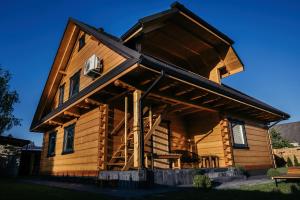 a log cabin with a wrap around porch at Sosnowy Zakątek Apartamenty in Józefów