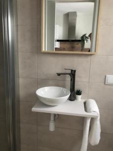 a bathroom with a sink and a mirror at APARTAMENTOS MESTRE in Ayamonte +9 photos