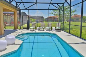 a swimming pool with chairs and a patio at Rose End Villa G in Davenport