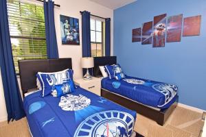 two beds in a room with blue walls at Rose End Villa G in Davenport