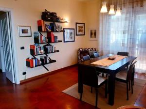 ein Esszimmer mit einem Tisch, Stühlen und einem Bücherregal in der Unterkunft Dilly Home Holiday-Casa vacanze in Aci Castello