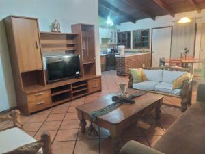 sala de estar con sofá, TV y mesa en Casa de Campo 4 habitaciones Ideal 12 personas, en Santa Cruz Verapaz