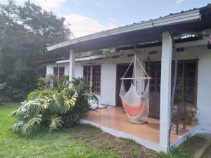 una casa con una hamaca en el porche delantero en Casa de Campo 4 habitaciones Ideal 12 personas, en Santa Cruz Verapaz