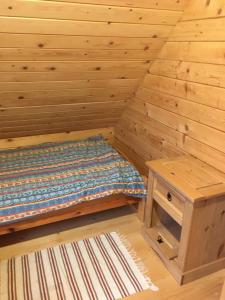 um quarto em madeira com uma cama e uma mesa em Domek z bala Mazury em Orzyny