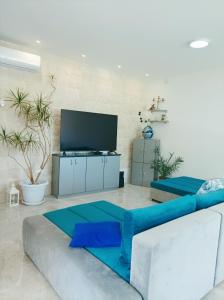 - un salon avec un canapé et une télévision dans l'établissement Green paradise, à Marina