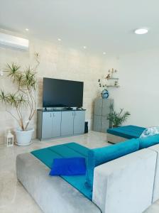 a living room with a couch and a tv at Green paradise in Marina