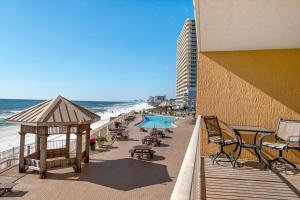 un balcón con sillas, una piscina y la playa en Treasure Island 0204, en Panama City Beach