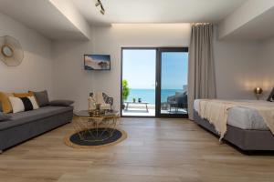 a bedroom with a bed and a couch and a view of the ocean at Akrogiali Luxury View in Laganas