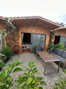 a patio with a table and a bench in front of a cabin at White Country Boutique Hotel in Antalya