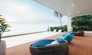 - un salon avec un canapé bleu et l'océan dans l'établissement Sea Season Pool Villa Pattaya, à Bang Lamung