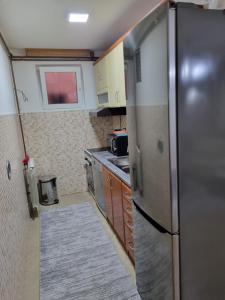 uma pequena cozinha com um frigorífico de aço inoxidável em Apartman- Sarajevo em Sarajevo