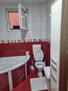 uma casa de banho vermelha e branca com um WC e um lavatório em Apartman- Sarajevo em Sarajevo