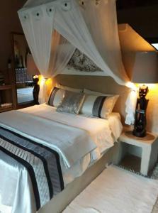 a bedroom with a white bed with a canopy at Canyon guest villa in Hoedspruit