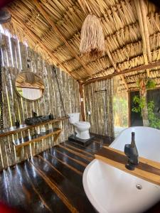 a bathroom with a bath tub and a toilet at Nuscaa Boutique Tree House & Spa in Puerto Morelos