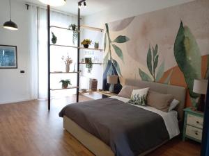 1 dormitorio con 1 cama y una pintura en la pared en Loft panoramico Caltagirone centro en Caltagirone