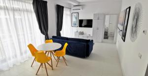 a living room with a blue couch and a table and chairs at OXYGEN NEPTUN BY BOUTIQUE C5 in Neptun