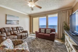 a living room with a couch and a flat screen tv at Treasure Island 2103 in Panama City Beach