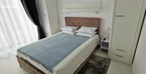 a bedroom with a bed with a blue blanket at OXYGEN NEPTUN BY BOUTIQUE C5 in Neptun