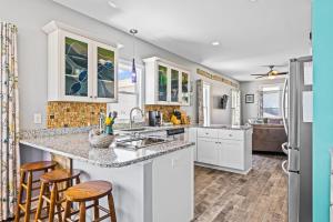 a kitchen with a sink and a counter with stools at Ocean Crystal A in Atlantic Beach