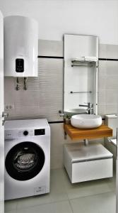 a bathroom with a washing machine and a sink at OXYGEN NEPTUN BY BOUTIQUE C5 in Neptun