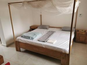 a bedroom with a canopy bed with white sheets at CasaCanda king size in Somone