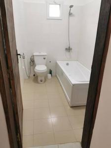 a white bathroom with a toilet and a bath tub at CasaCanda king size in Somone