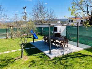 een huis met een picknicktafel en een schommel bij Vila Butoniga Nature in Buzet