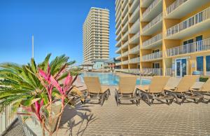 una fila de sillas junto a una piscina en un complejo en Treasure Island 0706, en Panama City Beach