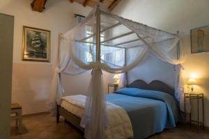 1 dormitorio con cama con dosel y ventana en MAREMMA TOSCANA [PISCINA & IDROMASSAGGIO], en Grosseto