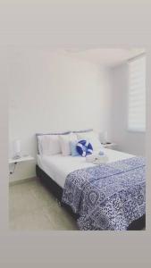 a bedroom with a bed with a blue and white blanket at Greece In Home in Girardot